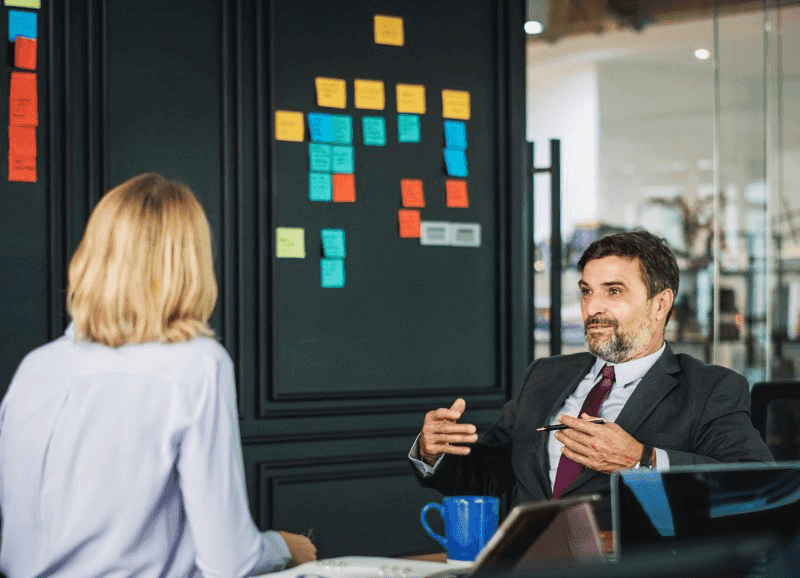 Advisor discussing a strategic plan with sticky notes on a board