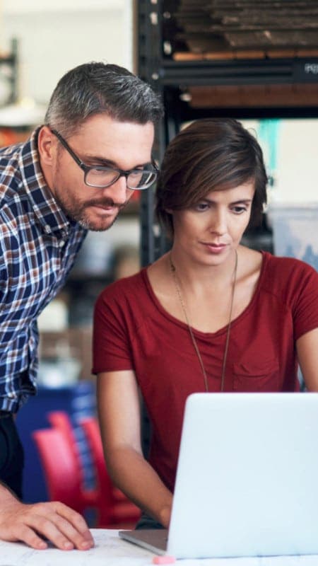 Team members reviewing work together on a laptop