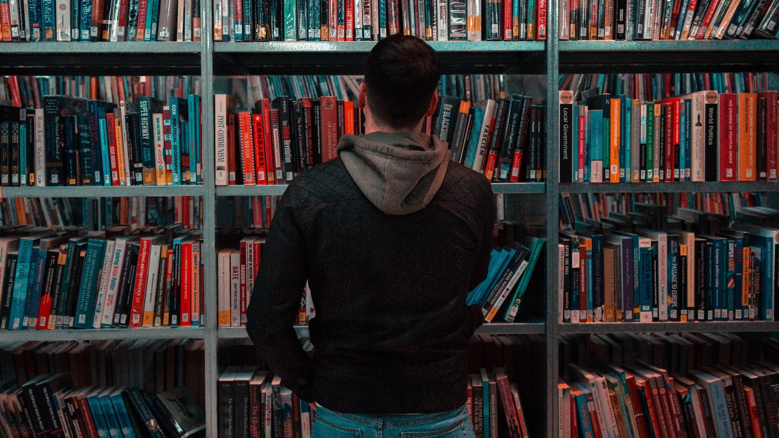 man looking at shelf of business books