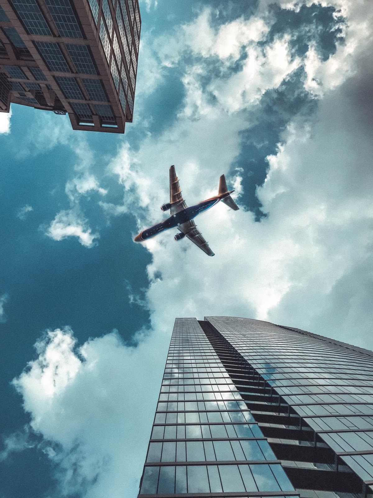 plane flying above buildings